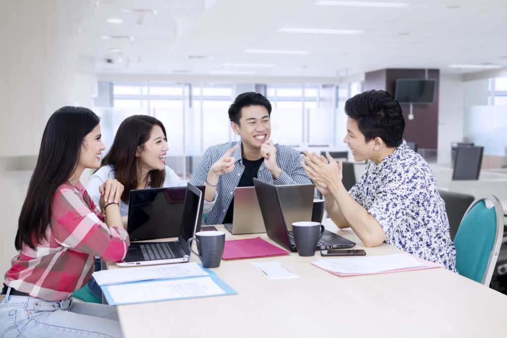 Group of business people looks happy while brainstorming together at the meeting and working in the office